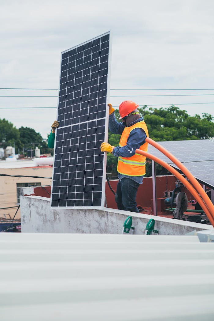 A technician in safety gear installs a solar panel on a rooftop, promoting renewable energy.